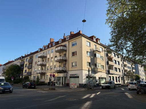 Mehrfamilienhaus vor der Sanierung: Unveränderte Fassade ohne Dämmung, originaler Dachüberstand und tief auskragende Balkongeländer.